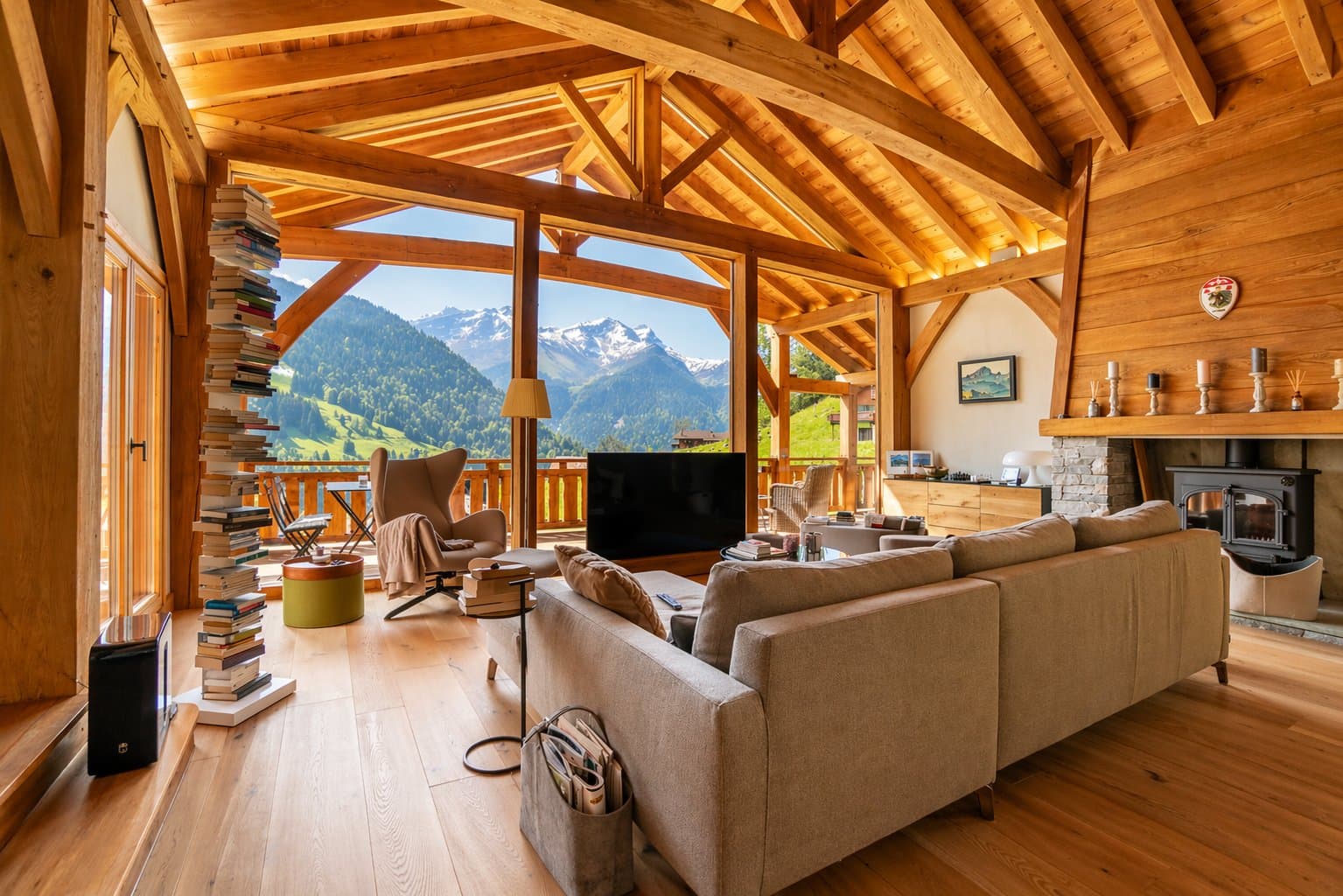Séjour de chalet baigné de lumière avec vue sur les sommets des Alpes vaudoises